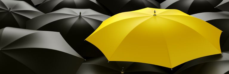 Yellow umbrella standing out amongst black